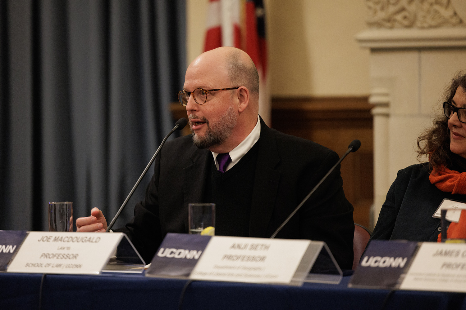 Joe MacDougald sits at table during panel discussion.