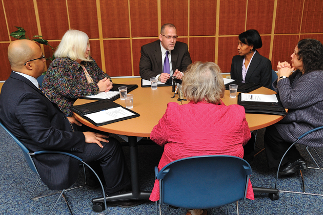 Catherine Havens ’74 MSW, ’84 JD, center with back to camera, leads a roundtable discussion on current issues in social work with alumni from the School of Social Work. Clockwise from left, Carlos Rivera ’94 MSW, Patricia Wilcox ’78 MSW, Joseph Bisson ’93 MSW, Heidi McIntosh ’92 (SFS), ’98 MSW, and Robin McHaelen, ’94 MSW.