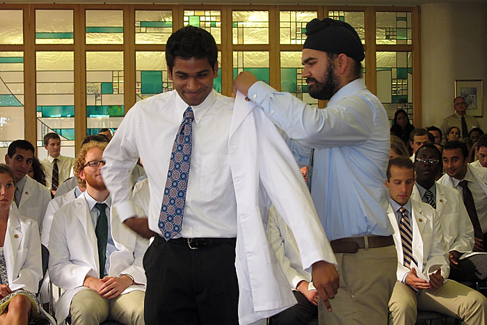 A medical student receives his white coat at the White Coat Ceremony, April 19, 2011. (Jennifer Beardsley/UConn Health Center Photo)