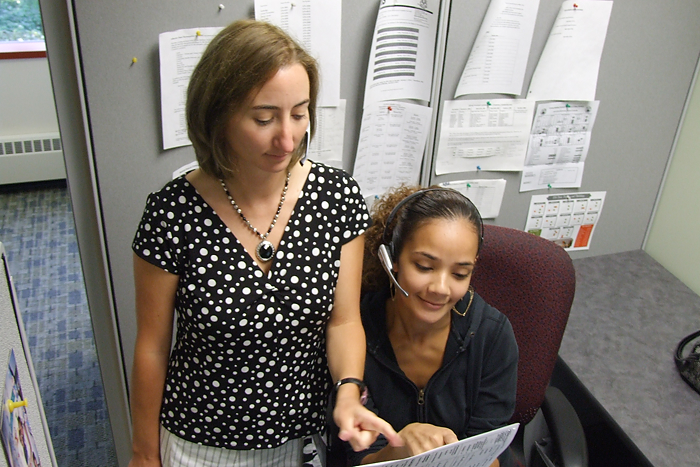 Milissa Woodward, manager of UConnLink Call Center, talks with representative Angelis Almenas. (Tina Encarnacion/UConn Health Center Photo)