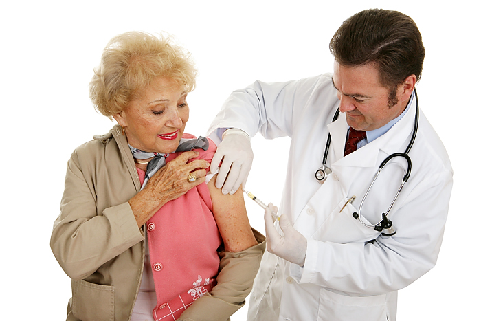 Senior woman receiving a flu shot from her doctor. (Stock photo)