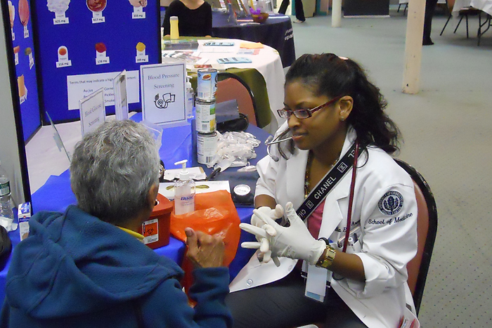 Fourth-year medical student Cynthia Emilie Armand sees a patient at the the 10th District Senior Fair in New Haven on November 30, 2010. (Bruce Gould for UConn Health Center)