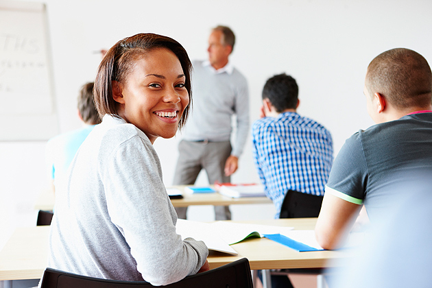 Student looking over shoulder while in class with friends.