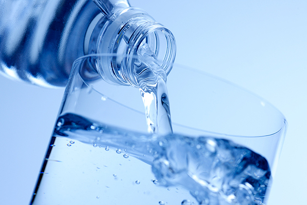 Bottle of water being poured into a glass.