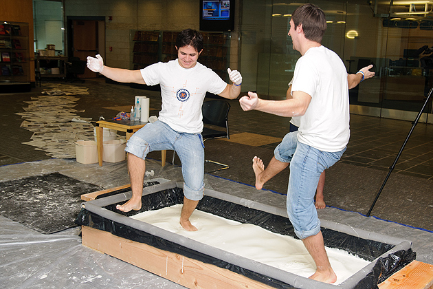 UConn engineering students play in a pool of oobleck (corn starch and water) as a live demonstration in the ITE lobby on Feb. 24, 2012. (Max Sinton for UConn)