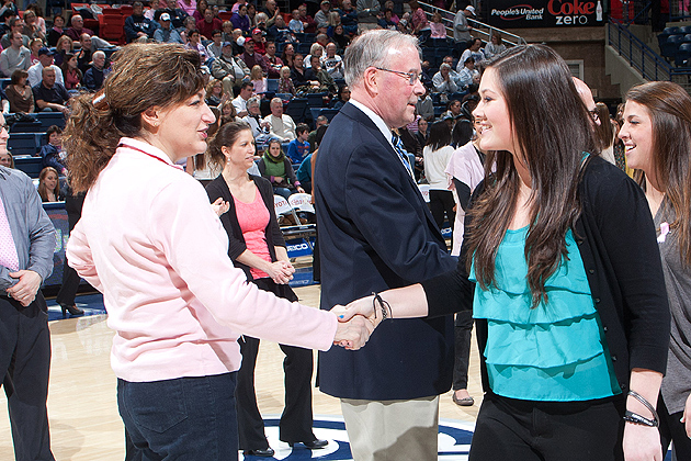 Marissa Guches'13 (CLAS), an outfielder for the Huskies softball team, is congratulated by President Susan Herbst for being among the more than 300 student-athletes who have attained at least a 3.0 grade-point average within the past academic year. The student-athletes were recognized on Feb. 11 for their success in the classroom during halftime of the women's basketball team game against Georgetown. (Steve Slade '89(SFA)for UConn)