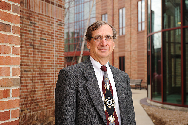 Gregory J. Weidemann, dean of the college of agriculture and natural resources stands outdoors with the Poultry Unit and Jacobson Barn over his shoulder on March 13, 2012. (Peter Morenus/UConn Photo)