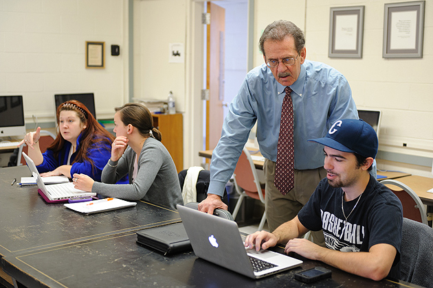 Marcel Dufresne, associate professor of journalism, speaks with Mac Cerullo '12 (BUS), right, about his reporting project on April 3, 2012. (Peter Morenus/UConn Photo)