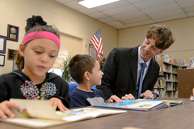 Michael Coyne, associate professor of educational psychology, reads with a group of first, second and third graders at the Windham Center School on Oct. 11, 2012. (Peter Morenus/UConn Photo)