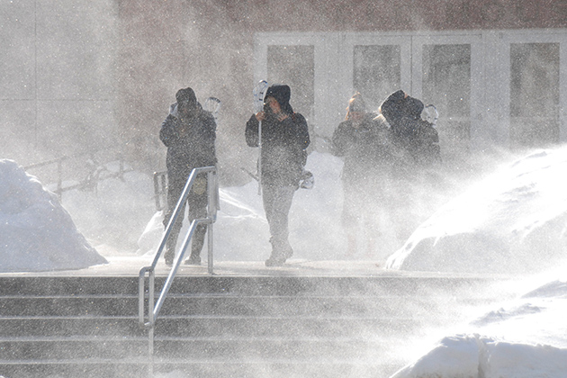 Students are overwhelmed with snow as they exit the Field House.