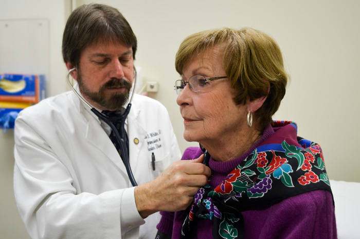 Dr. William White listens to the artery supplying blood to the brain of INFINITY trial participant Joan Larkins. (Chris DeFrancesco/UConn Health Photo)