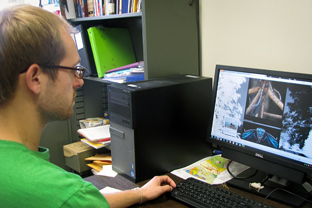 Mark Smith '13 MS Geoscience major and Innovation Quest award winner looking at his website on April 29, 2013. (Sheila Foran/UConn Photo)