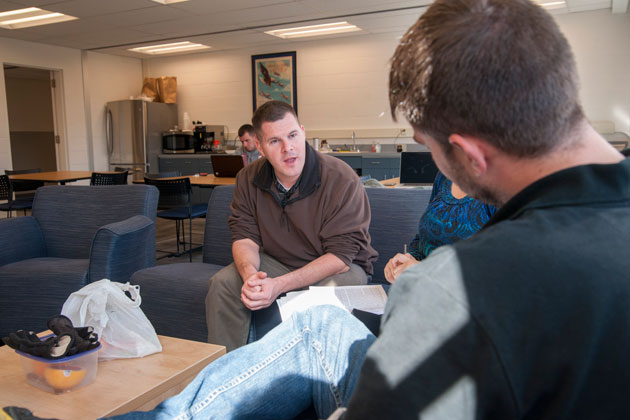 Kevin Evringham ’14, graduate assistant talking with Coleen Cranfill ’14 and Daniel Jones ’16 on Nov. 5, 2013. (Sean Flynn/UConn Photo)