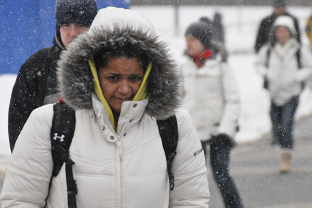 Students bundle up to keep warm while walking to classes on a snowy, winter day.