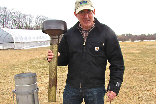 Steve Olsen '85 (CANR) lifts the internal precipitation measuring device out of its container. (Sheila Foran/UConn Photo)