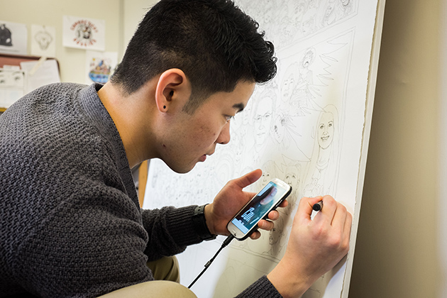 Hayato Kawai '14 (SFA) works on an illustration in a studio at the Bishop Center. (Peter Morenus/UConn Photo)