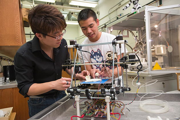 Senior chemical engineering student Derek Chhiv, right, discusses with Professor Anson Ma his group's prototype for an artificial kidney. The prototype was generated through 3-D printing. (Al Ferreira for UConn)