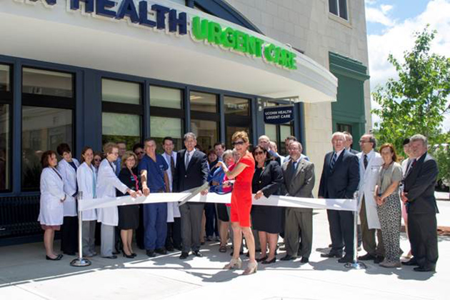 UConn officials, clinical staff, and elected officials join UConn President Susan Herbst (center) and Dr. Frank Torti, UConn Health executive vice president for health affairs (to Herbst’s right), for a ribbon cutting to mark the presence of UConn Health medical, dental, and urgent care services in Storrs Center. (UConn Health Photo)