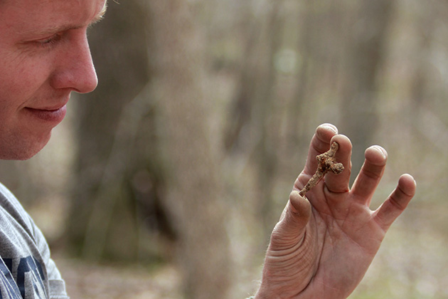 David Naumec ’00 (CLAS), military historian with the Pequot Museum examines an iron artifact found on a Pequot War battlefield. (Mashantucket Pequot Museum & Research Center Photo)