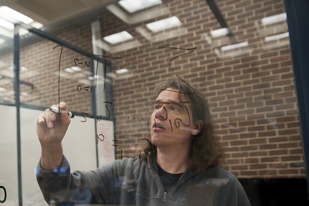 Ralf Schiffler, associate professor of math, ponders an equation. (Sean Flynn/UConn Photo)