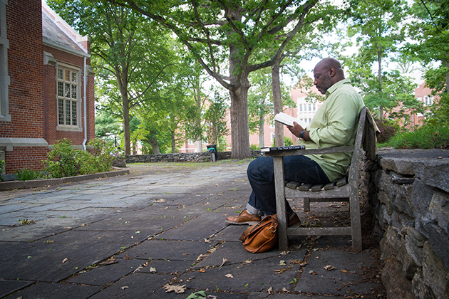 History professor Jelani Cobb, director of the Africana Studies Institute, reading a book in the Benton Museum courtyard. (Sean Flynn/UConn Photo)