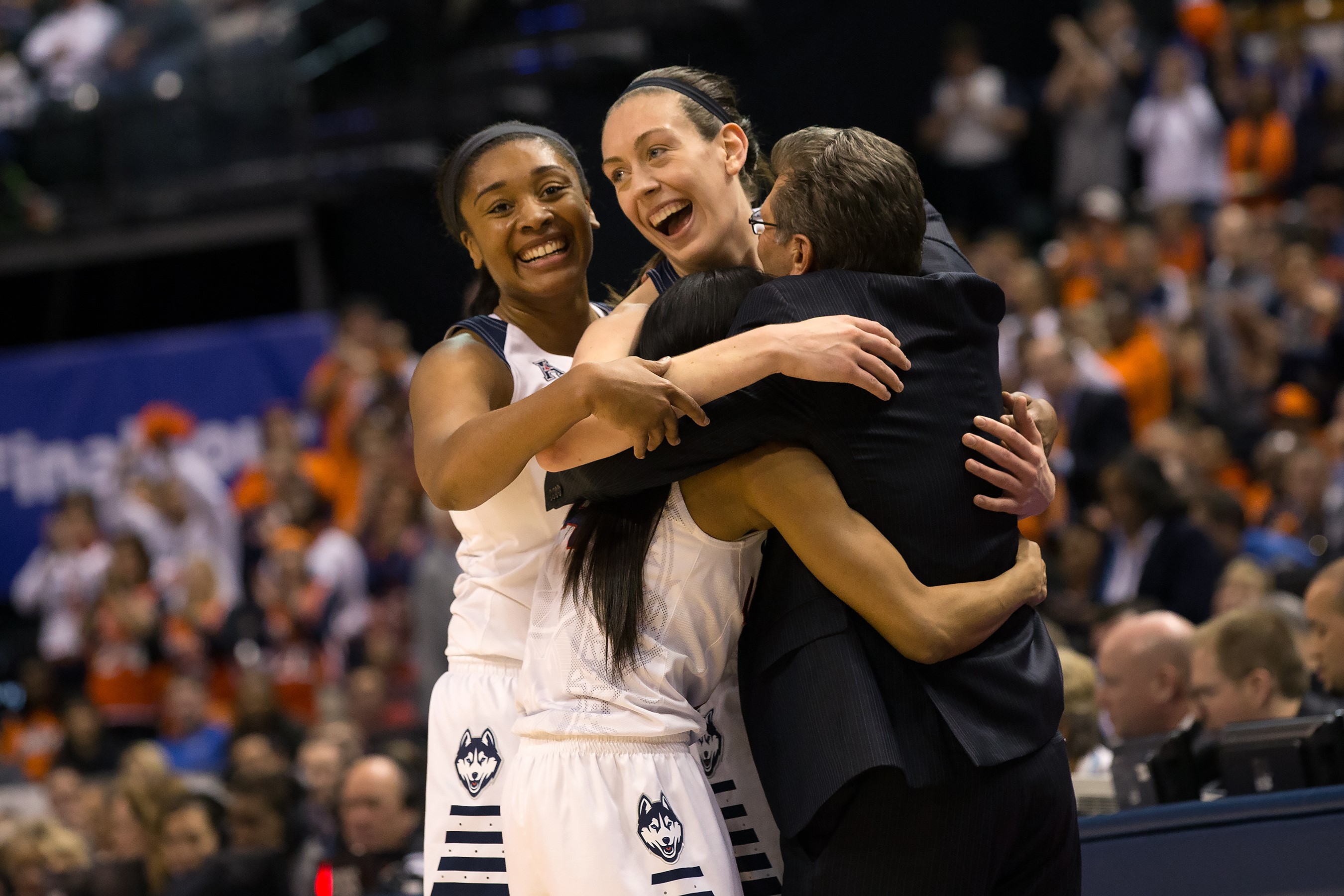 Seniors Morgan Tuck, Breanna Stewart, and Moriah Jefferson celebrate their fourth national title in a row with head coach Geno Auriemma. (Stephen Slade '89 (SFA) for UConn)