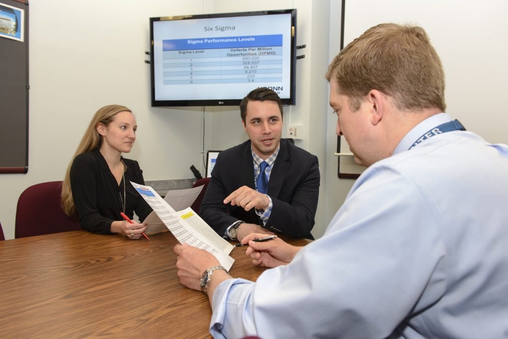 Graduate student commencement speaker Daniel Ray (center) will be doing a fellowship in hospital administration at UConn Health with Amanda Miller and Kevin Larsen. (Photo by Janine Gelineau)