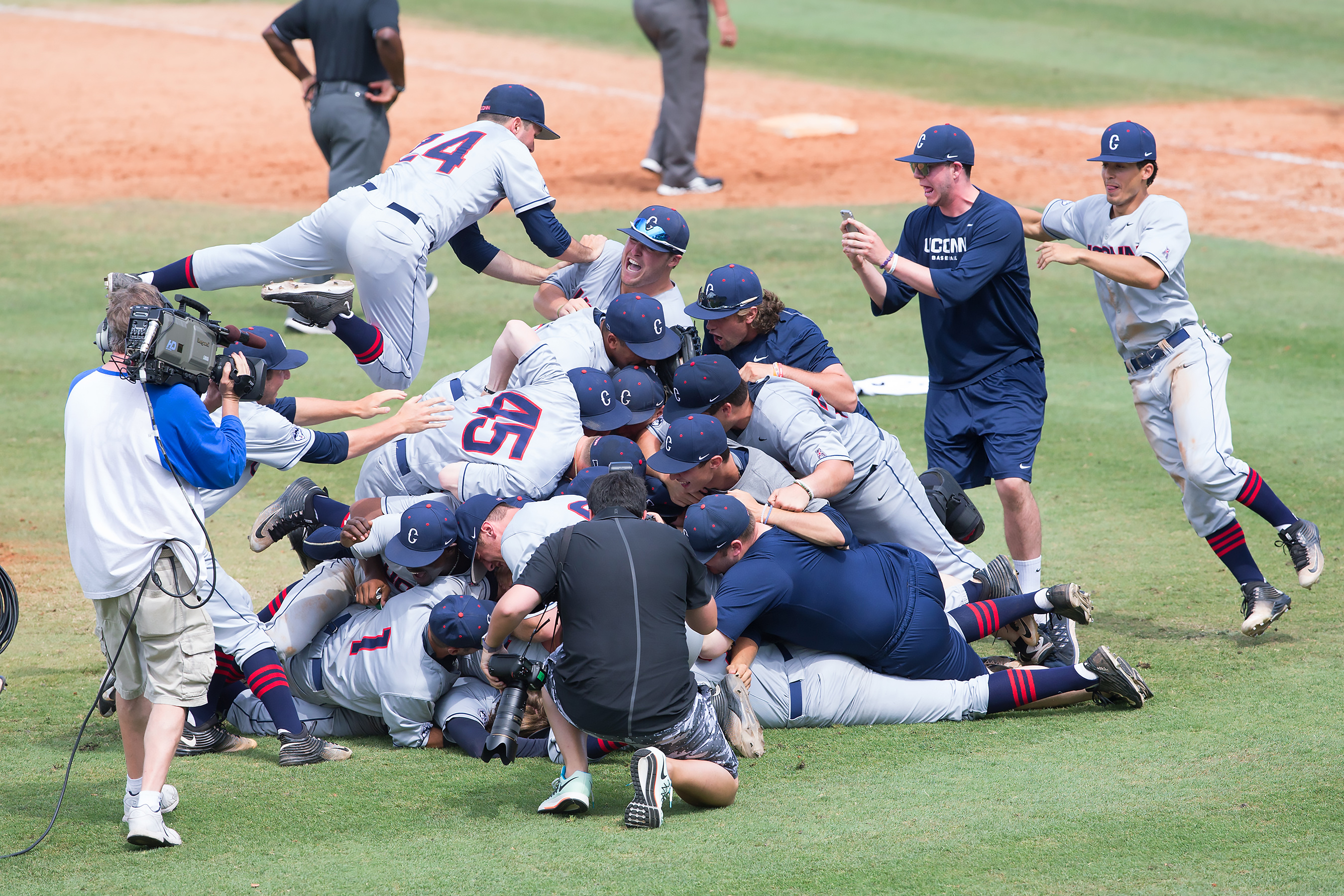 The team celebrates their 7-2 win over Houston to take the 2016 AAC Championship title. (Stephen Slade '89 (SFA) for UConn)