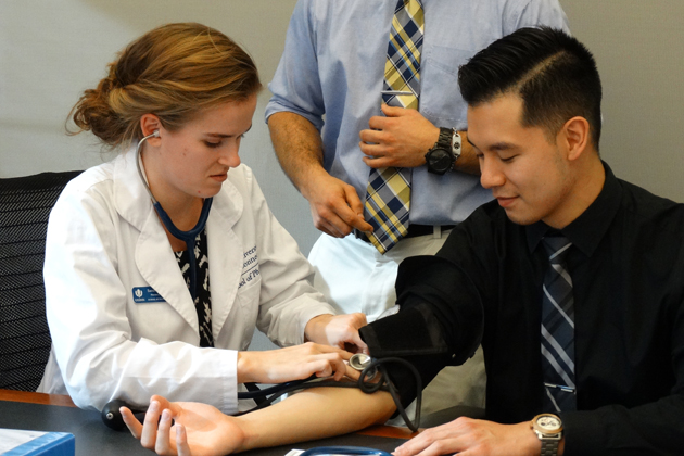 Pharmacy students learning to take blood pressure readings.