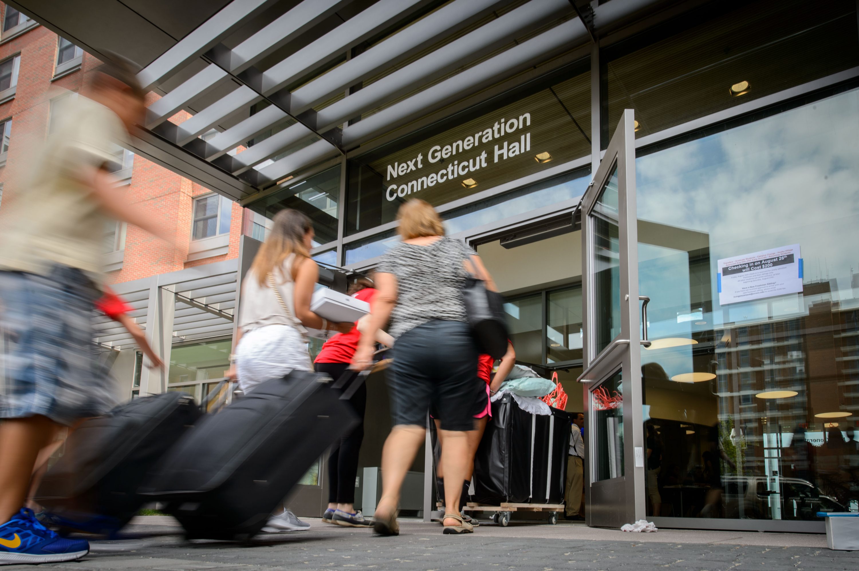 Students and family carry belongings into Next Generation Connecticut Hall on Aug. 26, 2016. (Peter Morenus/UConn Photo)