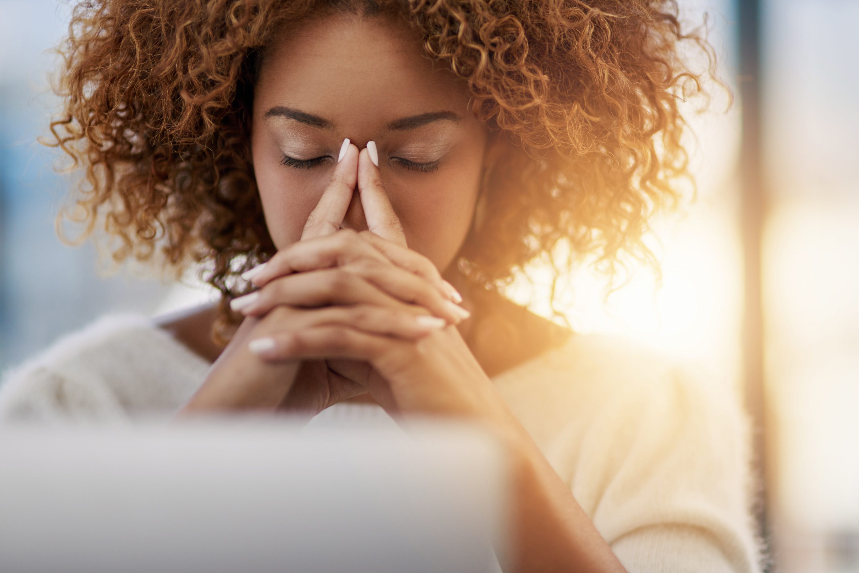 A young businesswoman with her eyes closed sitting in her office. (iStock Photo)