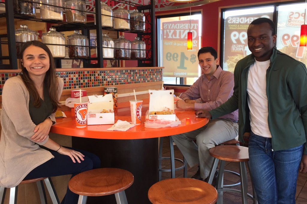 From left: Roma Romaniv, Joaquin Sanchez and Stephen Mwangi--the team of undergraduate finance students who took place in the Cornell Stock Pitch Challenge--pictured at a Popeyes Restaurant. (UConn photo)