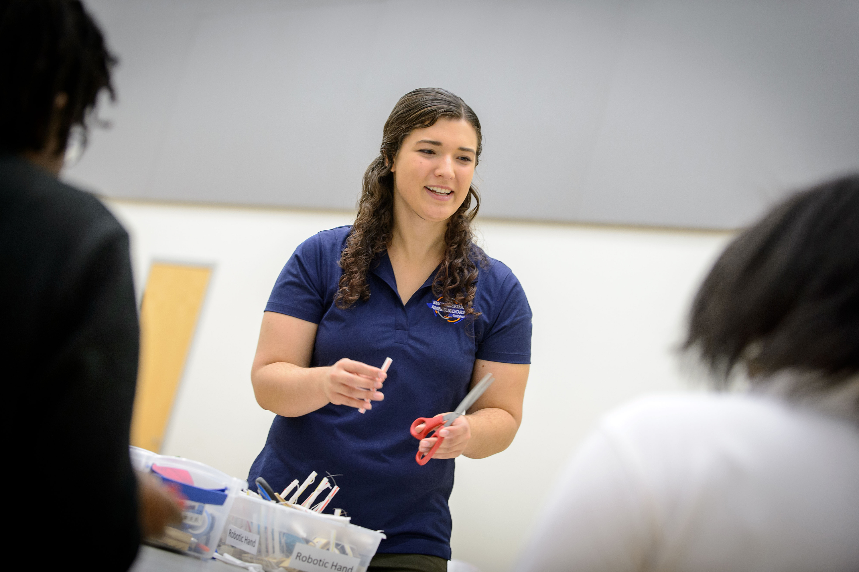 Phoebe Szarek '17 (ENG) helps eighth grade students from Carmen Arace Middle School in Bloomfield build robotic hands at the Student Union Ballroom on Oct. 5, 2016. (Peter Morenus/UConn Photo)