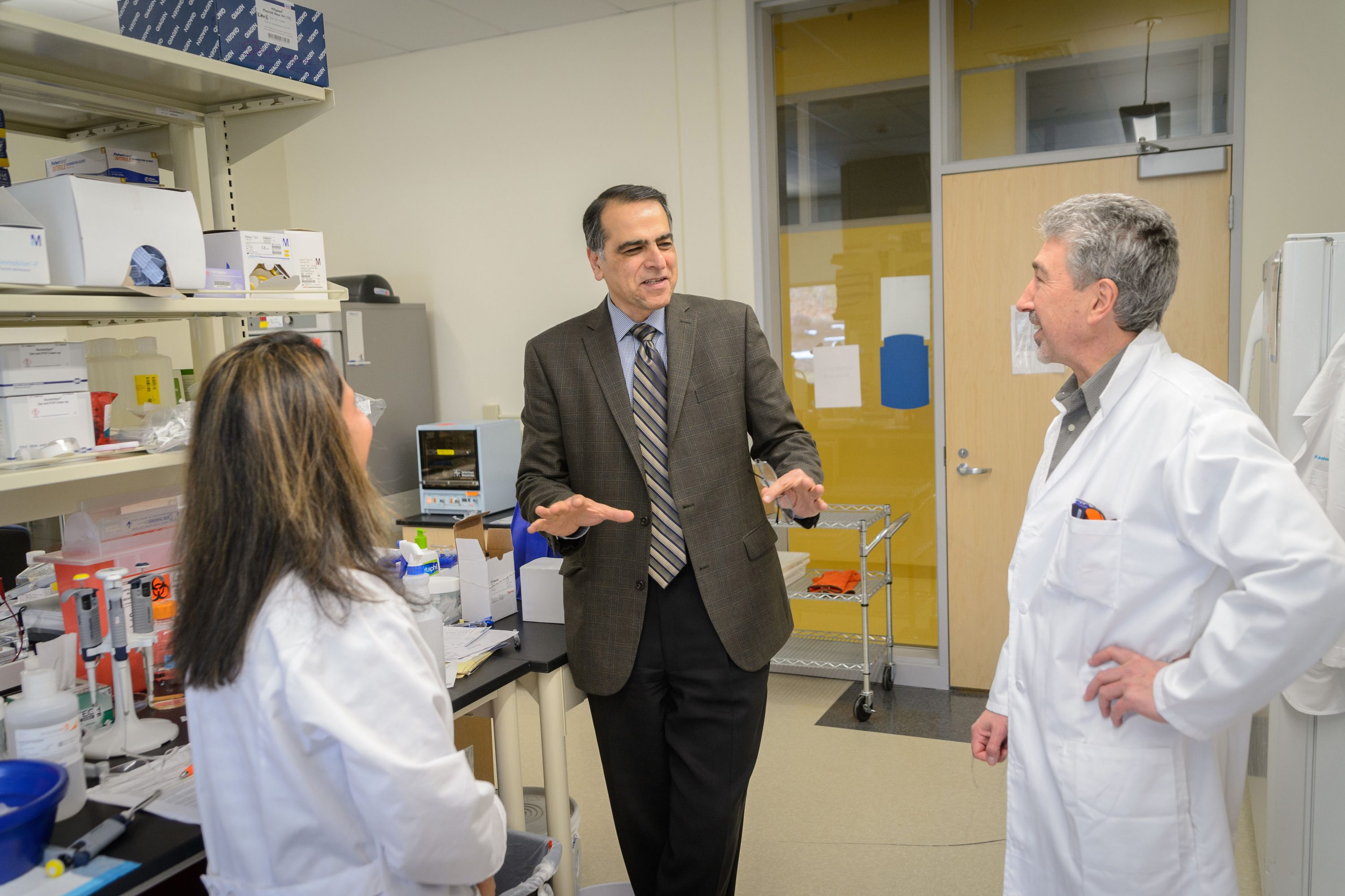 Mostafa Analoui, executive director of venture development, speaks with Kashmira Kulkarmi, chief scientist, and Alex Tikhonov, senior scientist at Azitra's technology incubator lab at the Cell and Genome Sciences Building in Farmington on Feb. 8, 2017. (Peter Morenus/UConn Photo)