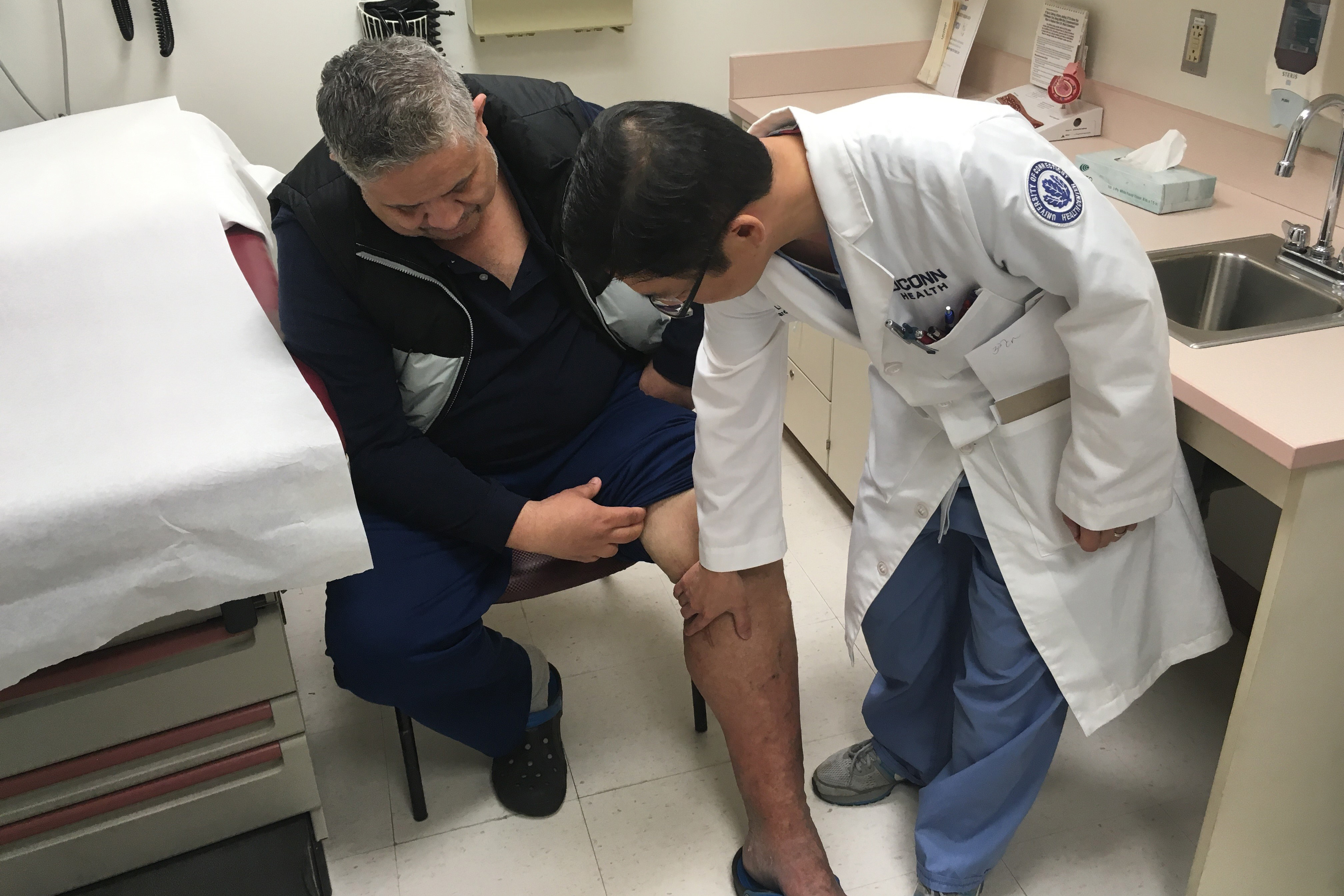 50 year-old Eliseo Bonilla, seated, with his UConn Health cardiologist Dr. JuYong Lee. (Lauren Woods/UConn Health Photo)