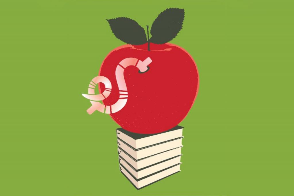 Apple with a dollar sign worm eating into it, on top of a pile of books. (Gillian Blease via Getty Images)