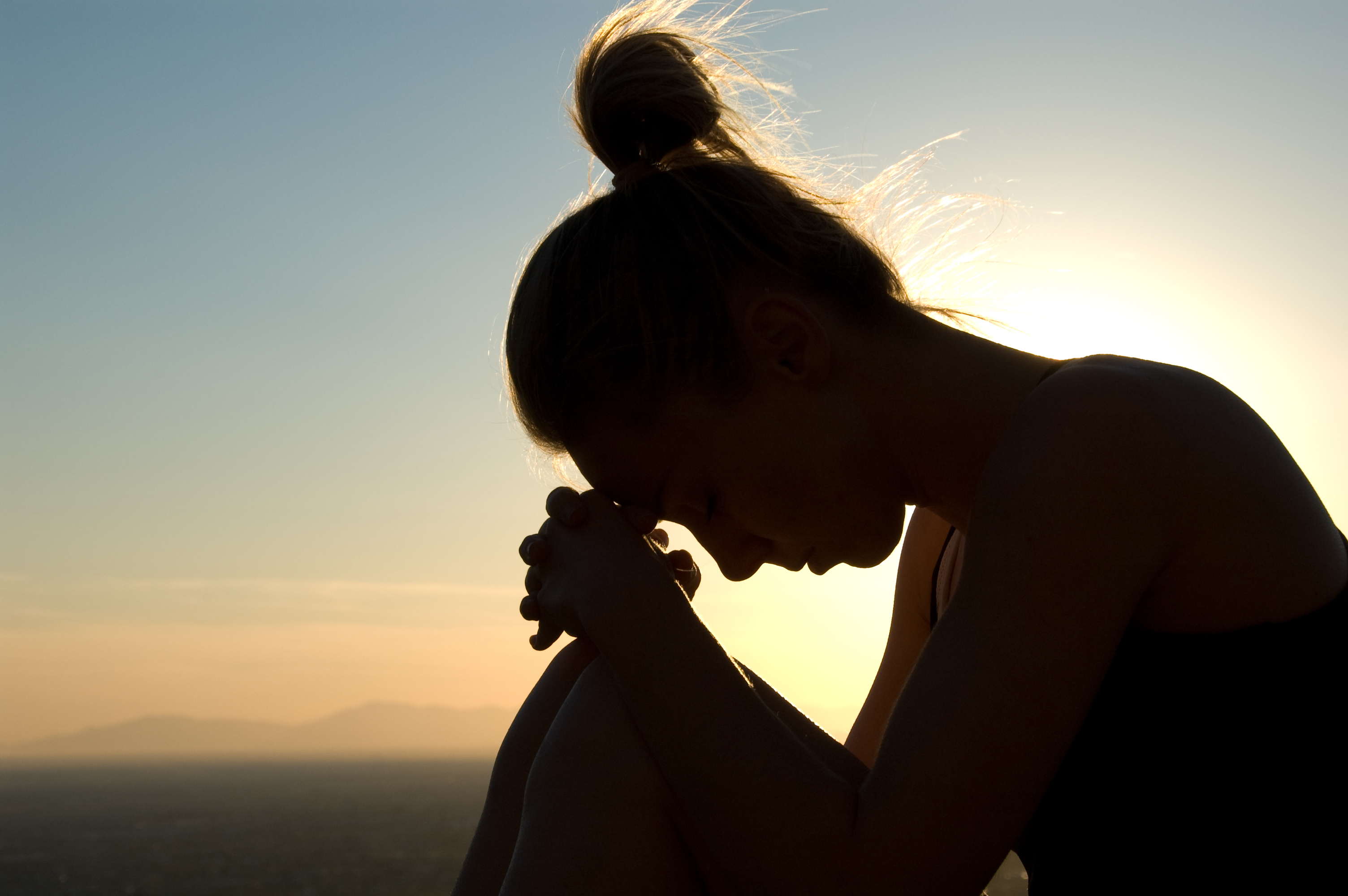 A woman deep in thought at the top of a mountain. (PeteWill via Getty Images)