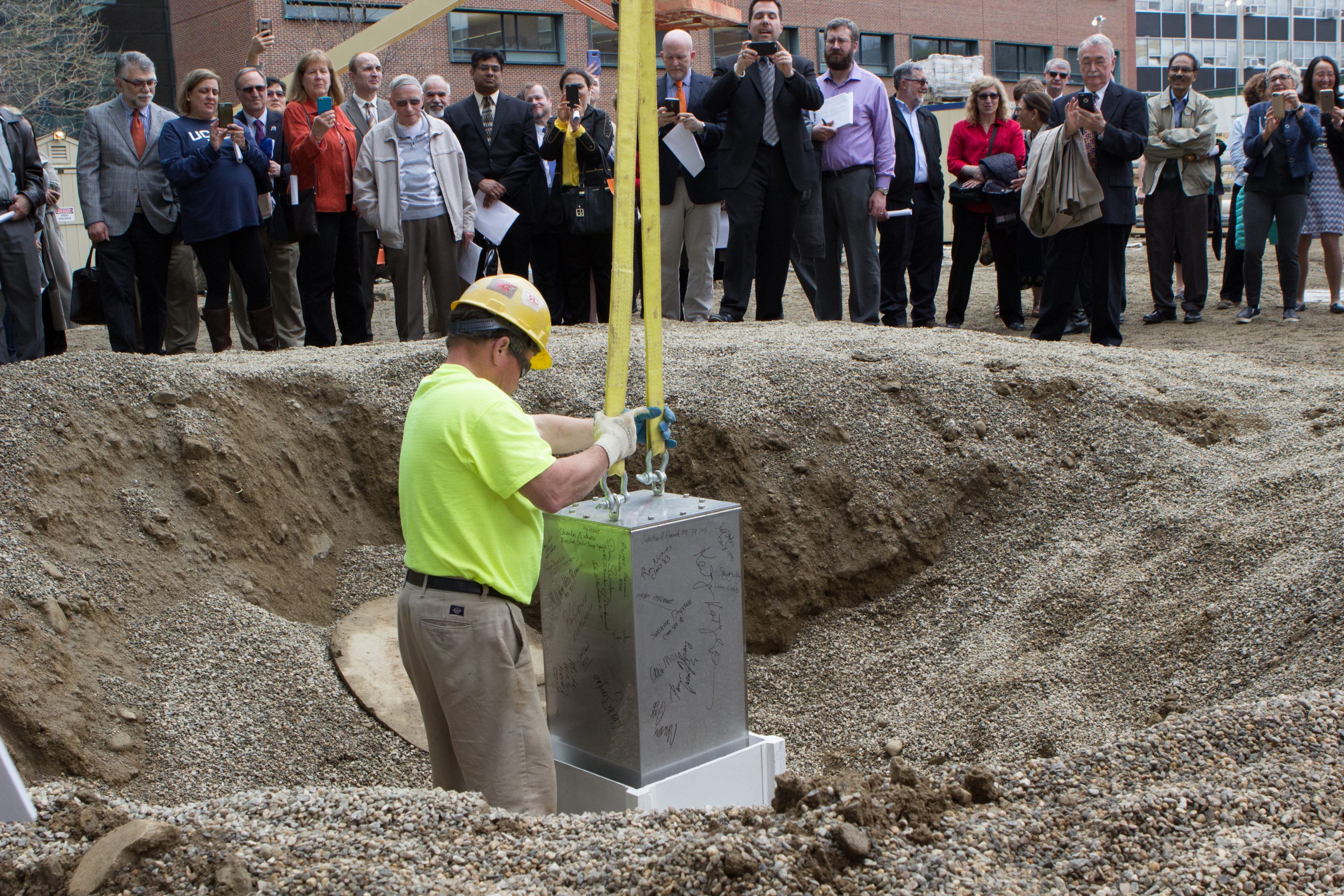 A construction worker lowers the time capsule into an ultra-high performance, fiber-reinforced concrete vault that will hold it for the next 100 years. (Christopher LaRosa/UConn Photo)