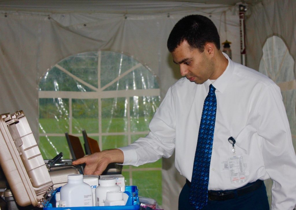 John Aurora '17 (Pharm.D.) starts unpacking some of the items donated by CVS and Walgreens at the start of a clinic held in September.