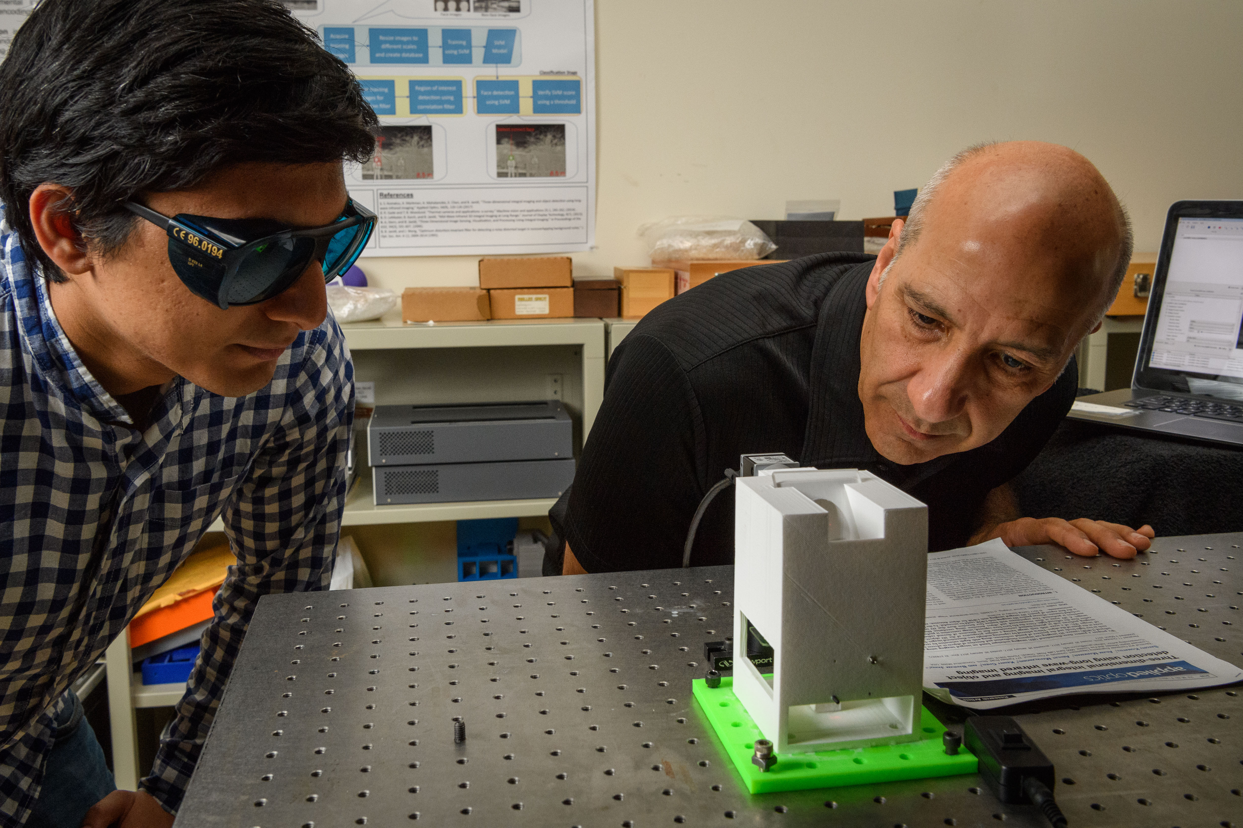 Siddharth Rawat, left, a Ph.D. student, and Bahram Javidi, distinguished professor of electrical and computer engineering, operate a prototype device to examine blood samples for diseases at the Information Technologies Engineering Building (ITE) on Sept. 28, 2017. (Peter Morenus/UConn Photo)