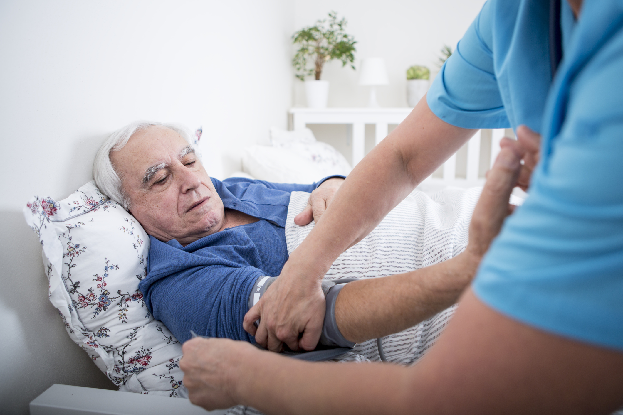 Geriatric nurse measuring blood pressure of patient. (Getty Images)