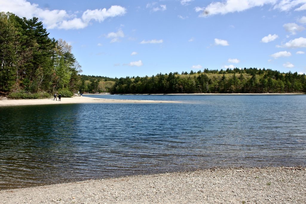 A view of Thoreau’s Cove from the western side at Stop 10. Two people on the beach provide scale. (Robert Thorson/UConn Photo)