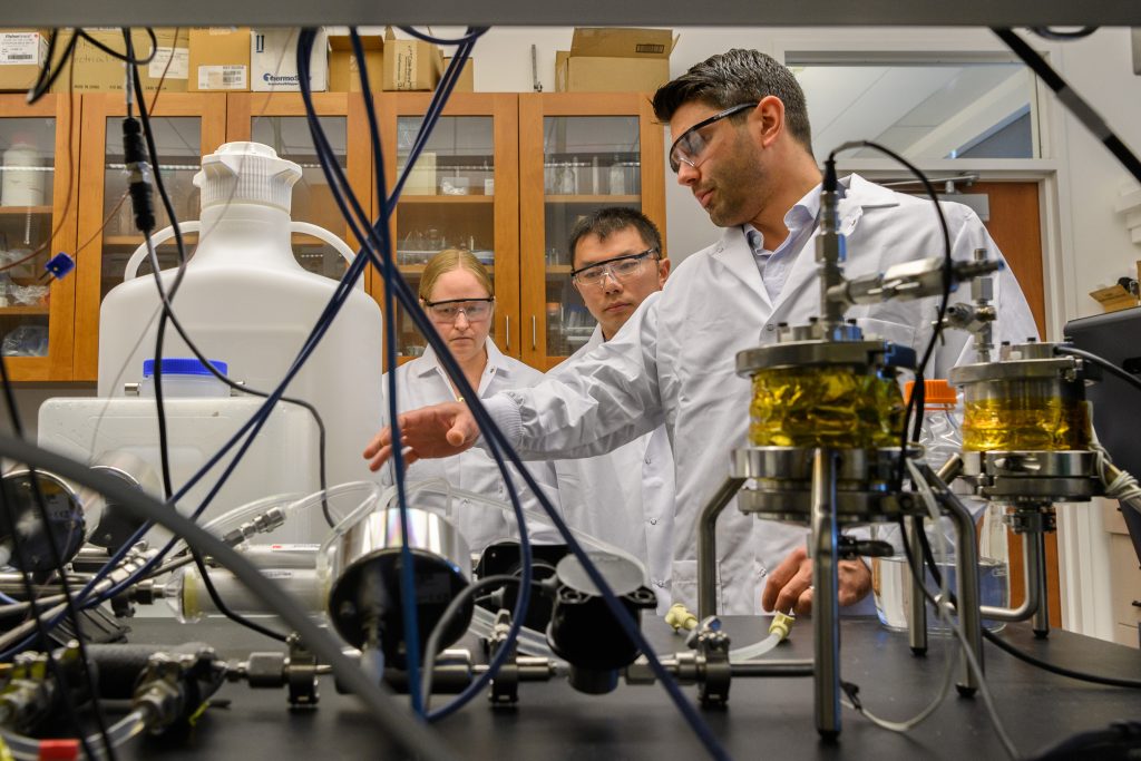 Antonio Costa, assistant research professor of pharmaceutical science, right, explains the apparatus for continuous processing of liposome drug products to Katherine Tyner and Su-Lin Lee, both of the FDA’s Office of Pharmaceutical Quality, at the Pharmacy/Biology Building. (Peter Morenus/UConn Photo)