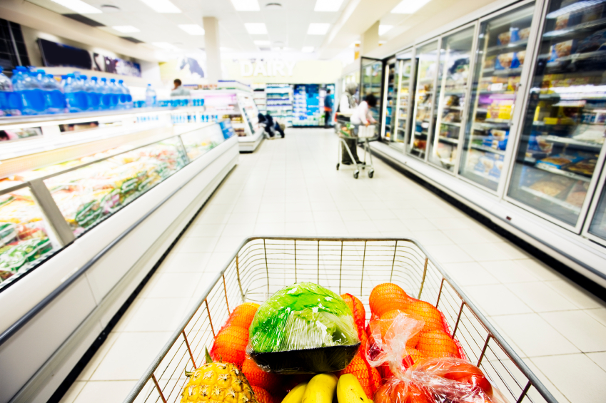 Grocery cart with food in it going down a grocery isle