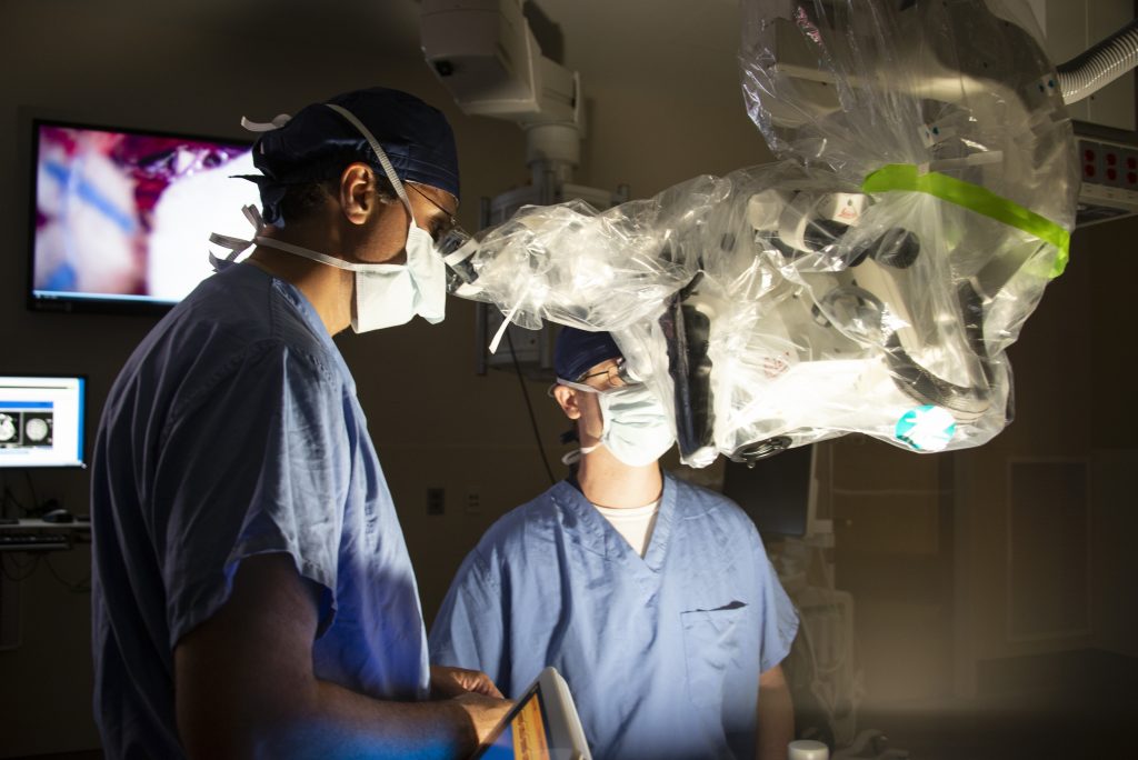 Ketan Bulsara, M.D., M.B.A, and Daniel Roberts M.D., Ph.D., with the new Augmented Reality Microscope in the Hybrid OR at UConn John Dempsey Hospital. (Kristin Wallace/UConn Health Photo)