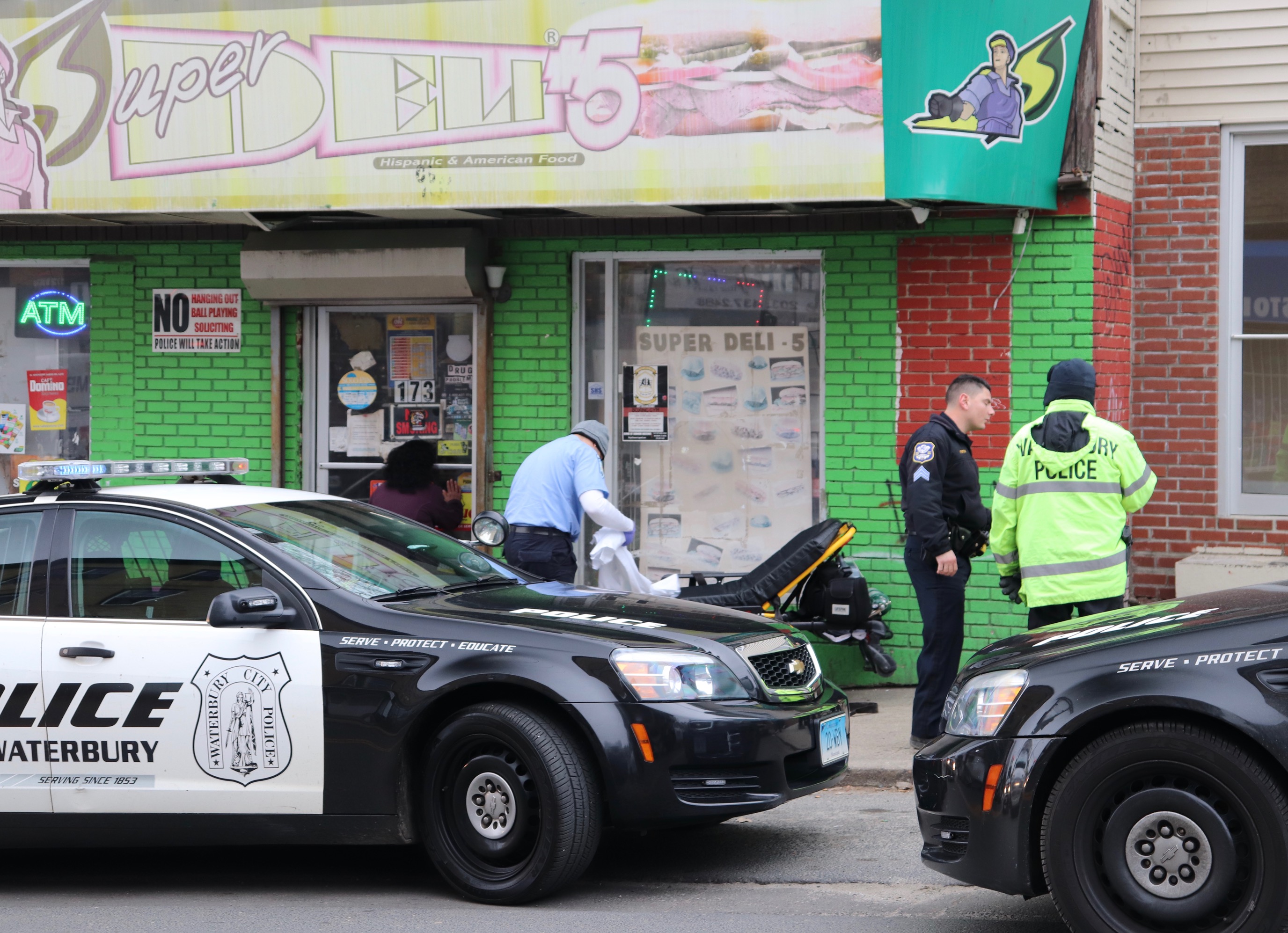 Waterbury police officers gather around a stretcher on a city street after an opioid overdose.