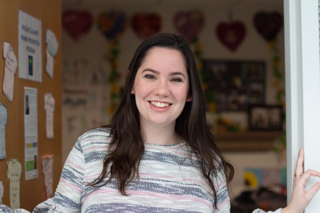 Kelly Flanner, a 2020 MPA graduate, poses in front of her office at the Women's Center.