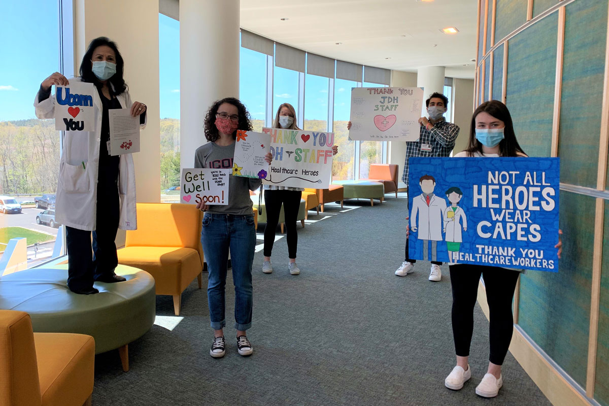 Allied health students hold posters of support for patients and staff