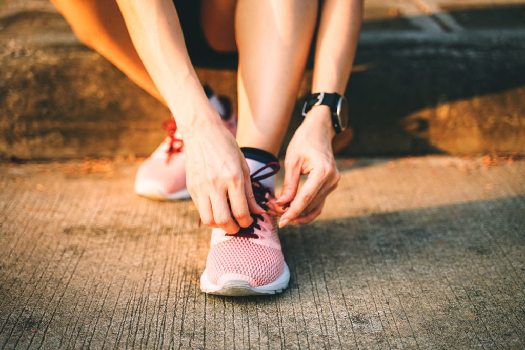 Woman tying running shoe