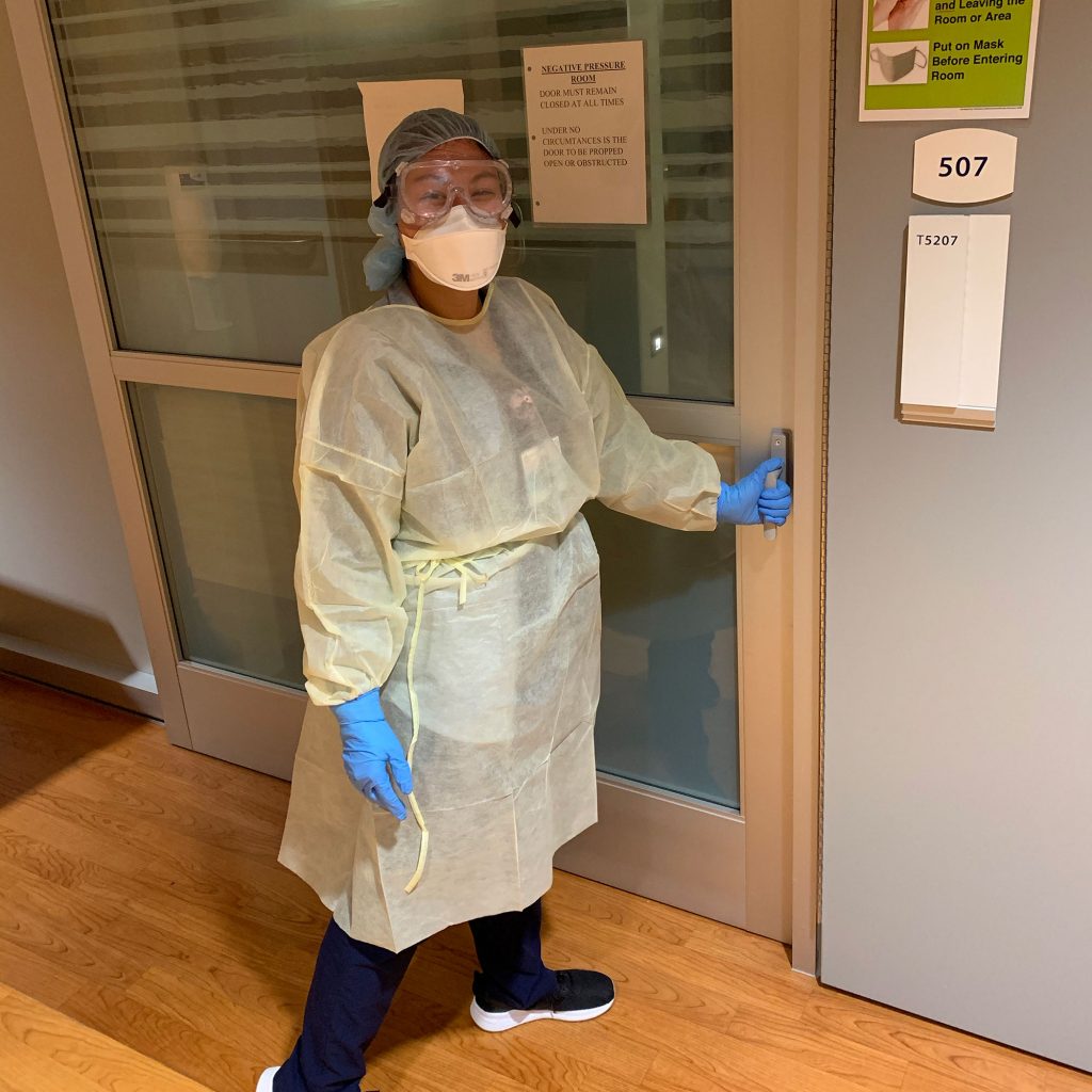 Nurse standing outside emergency room door.